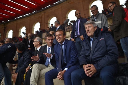 Nicolas de Villiers talks to Emmanuel Macron while sitting in the theme park’s stands