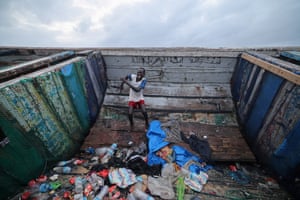 A boy smiles and dances inside an empty boat