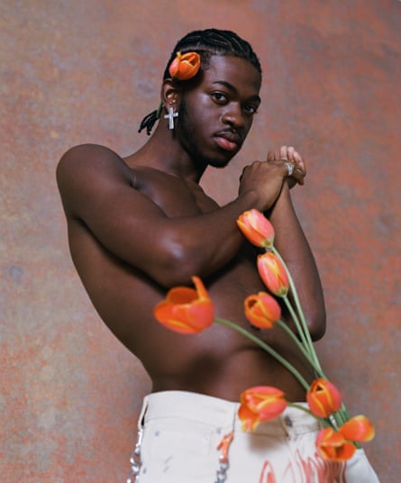 Lil Nas X topless with a tulip behind his ear