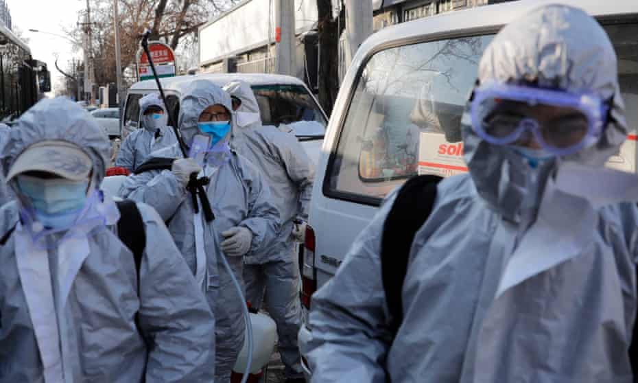 Workers in protective suits after disinfecting a residential area in Beijing, China, to control the spread of coronavirus