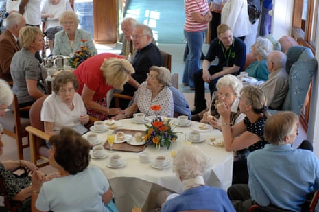 Elderly residents receiving visits from family members within a residential care home setting.