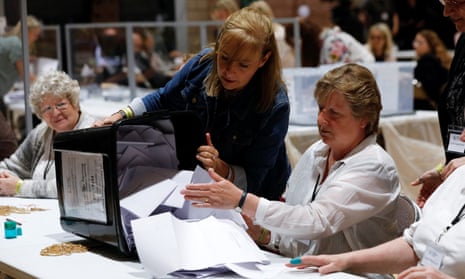 Woman pours ballot papers on to a table