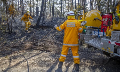 Queensland firefighters put out spot fires on Binna Burra Road on 12 September.