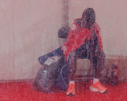 The runner Ruth Chepngetich sits huddled under a blanket inside a tent after running the London Marathon.