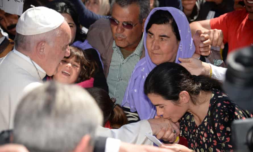 A woman kisses the hand of Pope Francis as he greets people at the Moria refugee camp.