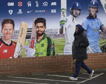 A man walks past a poster for a shop selling cricketing merchandise in Bradford, England.