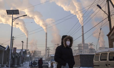 A Chinese woman wears a mask while walking in a neighbourhood next to a coal-fired power plant in Shanxi, China. 