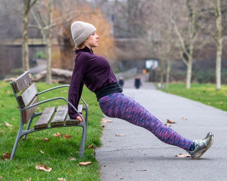 Abi Millar doing tricep stretches on a park bench