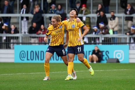 Kiko Seike of Brighton & Hove Albion (R) celebrates scoring her team's first goal with teammate Maisie Symonds.