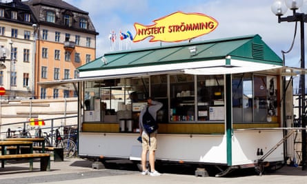 Customer at the snack bar with sale of freshly fried herring at Sodermalmstorg in Stockholm.MJDMP6 Stockholm, Sweden - July 10, 2016: Customer at the snack bar with sale of freshly fried herring at Sodermalmstorg in Stockholm.