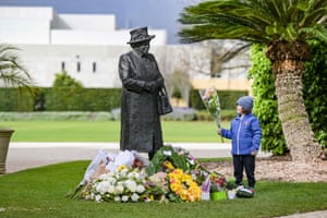 Ten-year-old Ben places flowers at the base of a statue of Queen Elizabeth II at Government House in Adelaide on 9 September.