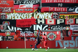 David Alaba in action with Paulinho during the match in front of fan banners.
