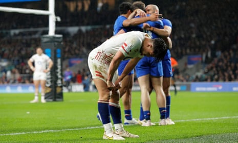 England's fly-half Marcus Smith reacts as France's wing Damian Penaud celebrates with teammates after scoring their sixth try.