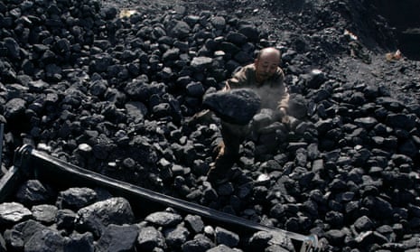 A man loads coal on to a cart in Shaanxi province, where 19 miners have after a coalmine collapse.