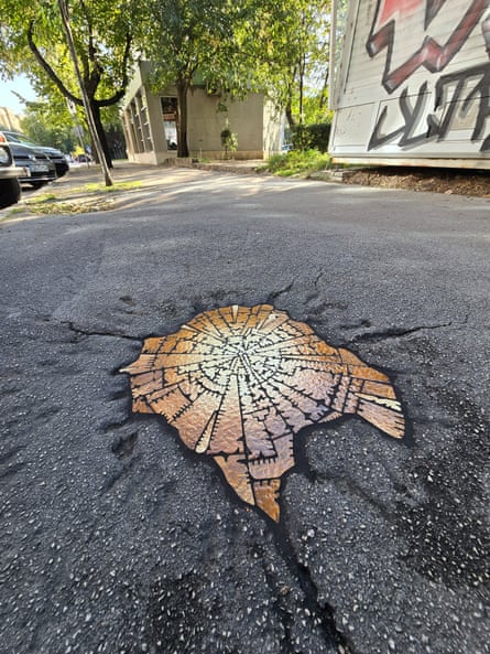 Mosaic design by artist Ememem fills crater in concrete ground