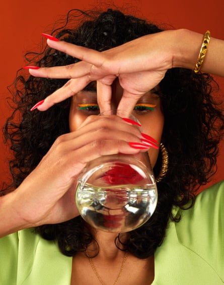 Close-up shot of a woman pinching her nose while drinking form a glass of water