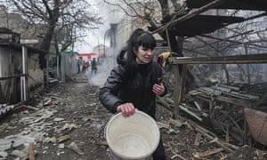 A woman walks past the debris in the aftermath of Russian shelling in Mariupol, Ukraine.