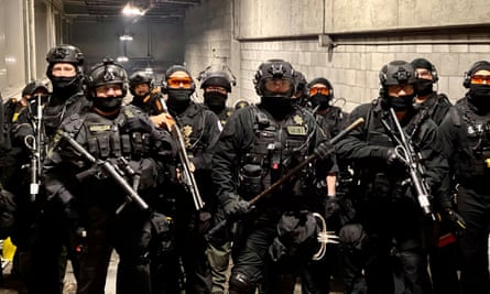 Riot police stand in a garage on Portland during a confrontation with protesters on Friday night.