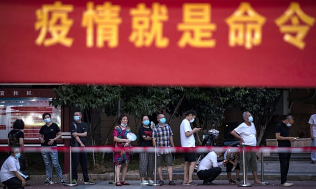 Residents line up for Covid-19 tests near a banner with the words ‘Epidemic is the order’ in Wuhan in central China’s Hubei province