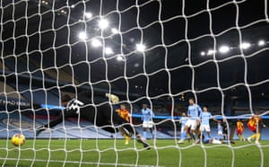 Manchester City’s Ederson dives but is beaten by the deflection off Dias.