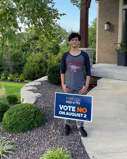 Quinn Patel, 19, stands outside his parent’s home in Kansas City with his vote no sign.
