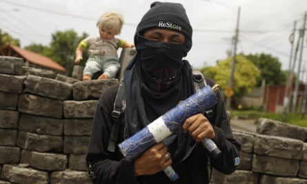 A young man poses with a handmade weapon, in front of a street barricade in Managua, Nicaragua, 15 June 2018.