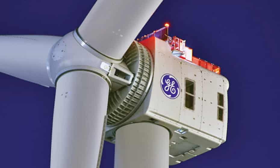 Close up of the head and boss of a giant wind turbine against a dark blue sky