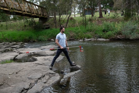 Alex Hall, a PhD student in the Lithgow lab at Monash University, holds a water sample from Merri Creek