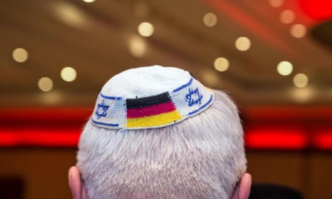A man wearing a Jewish kippah skullcap with the flags of Germany and Israel. 