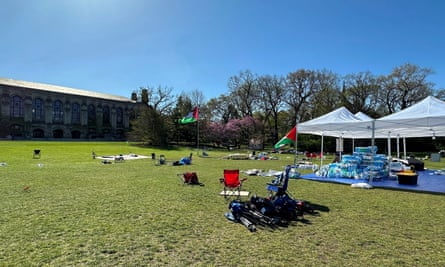 Large green lawn, with a couple pop-up tents and a few chairs.