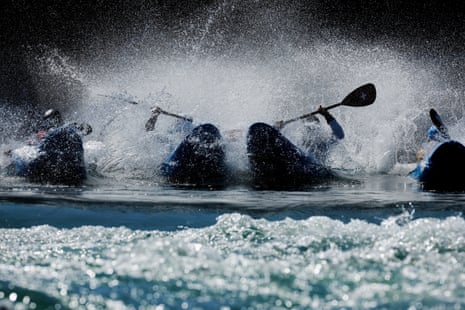 Competitors in the men’s quarter finals of the kayak cross are seen splashing into the water off the start ramp at the Stade Nautique.