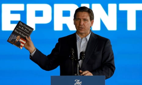 Florida governor speaking at an event holding his book in one hand