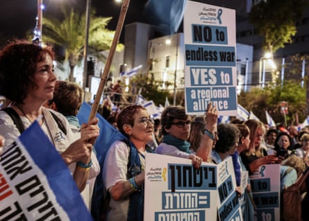 A line of middle-aged white women at a demonstration, holding placards in Hebrew and English with slogan such as: ‘No to endless war, yes to a regional alliance.’