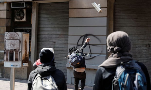 A demonstrator in Mexico City vandalises a surveillance camera during a march against the police violence days after riot police officers kicked a protester in the head while demonstrating against the deaths of George Floyd in the U.S. and Giovanni Lopez in Mexico.