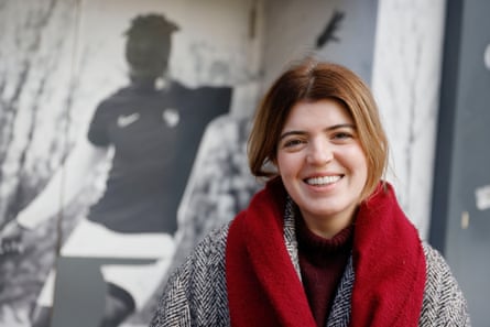 Rachel Breen smiles in front of a football poster