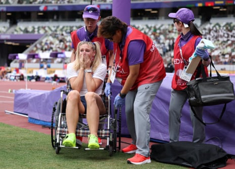 Molly Caudery puts her face in her hands while on a wheelchair after sustaining an injury during practice before the women’s pole vault qualification