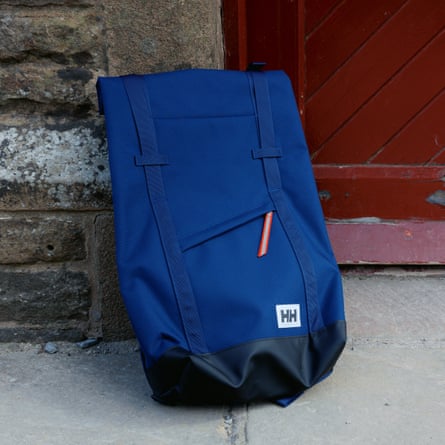 Helly Hansen Stockholm backpack, 28l on the ground next to a brick wall and red door