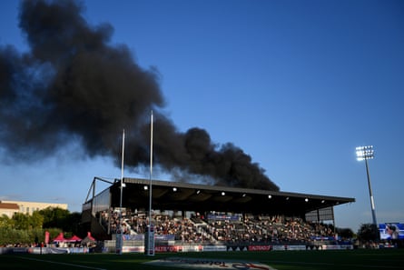 Black smoke rises from a bus that was on fire near the stadium during the Test