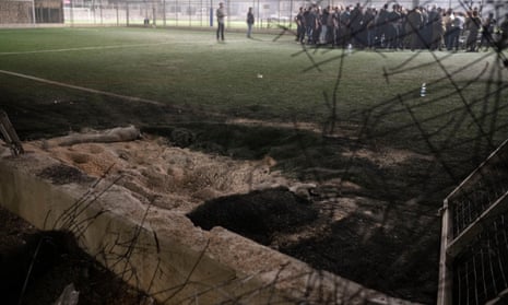 Residents gather with authorities at a football pitch that was hit by a rocket in the Druze town of Majdal Shams.