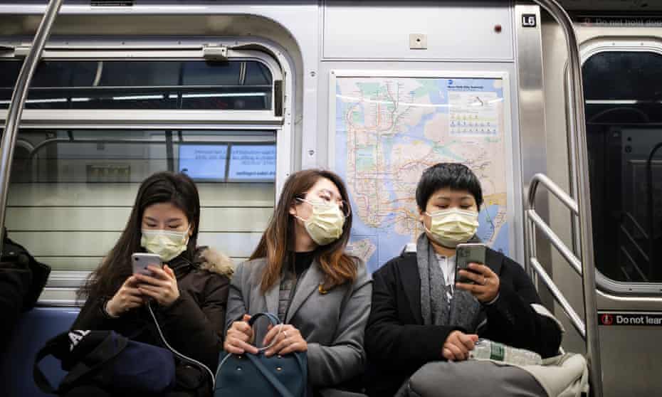 People wear masks to cover their faces while riding the subway in New York on 31 January 2020. 