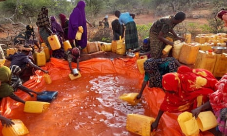 People collect clean water that has been privately bought and sent into an al-Shabaab controlled area.