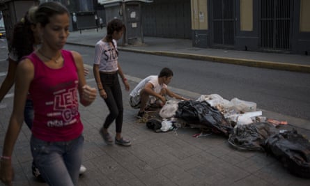 A man searches for food in the rubbish on a pavement in Caracas, Venezuela.