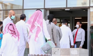 Costumers queue for a temperature check before entering a mobile shop in Saudi Arabia’s holy city of Mecca.