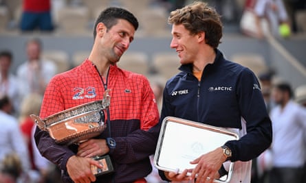 Novak Djokovic dan Casper Ruud dari Norwegia berpose dengan trofi pemenang dan runner up mereka setelah Final Tunggal Putra pada 11 Juni.