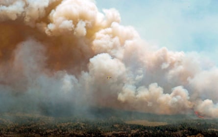 An aircraft in New Brunswick, Canada, drops fire retardant in Barrington Lake, Nova Scotia.