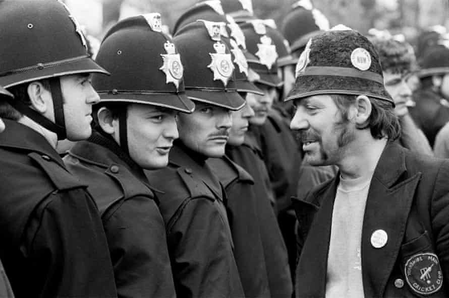 Picket wearing a joke police helmet talking to Police Officers without identification numbers at Orgeave, 6 June 1984