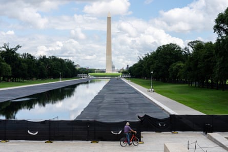a person on a bike looking at a reflecting pool