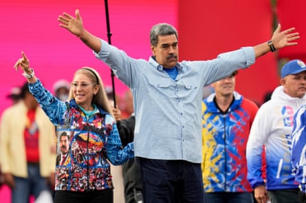 Nicolás Maduro and Cilia Flores with raised arms at a rally