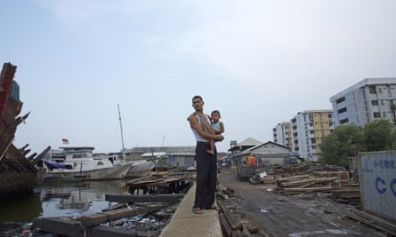 A man carries his baby along a seawall in an area lying more than a meter below sea level in the Maura Baru district in Jakarta, Indonesia. Jakarta, southeast Asia’s largest city is sinking slowly into the sea.