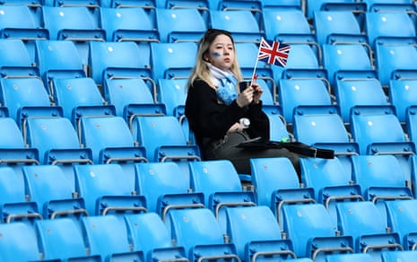 Seorang penggemar Manchester City mengambil tempat duduknya di Stadion Etihad setelah tampaknya berhasil dari penobatan Raja Charles.